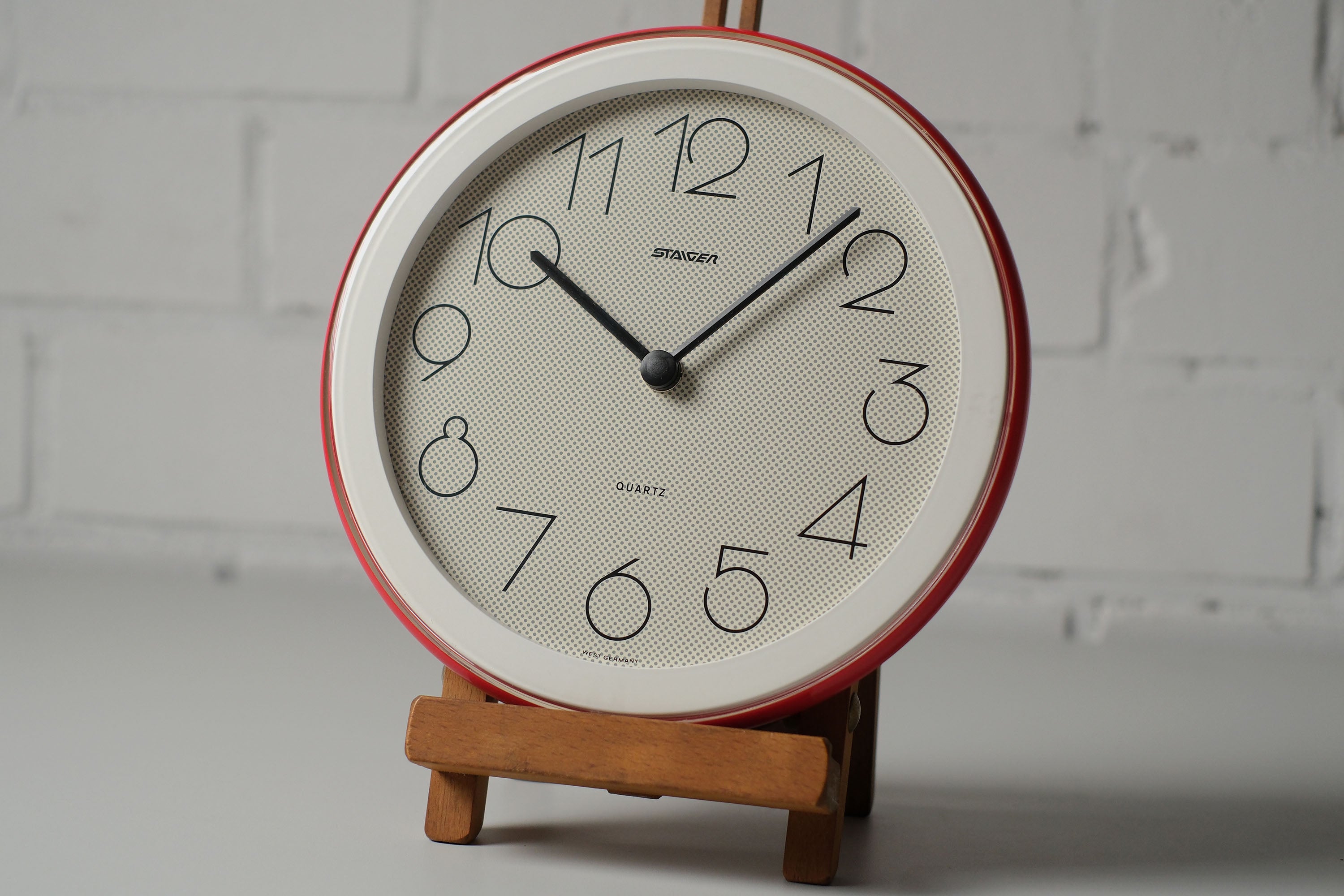 Vintage 1980s postmodern round wall clock by Staiger West Germany with pop-art dotted face, red and white plastic frame.