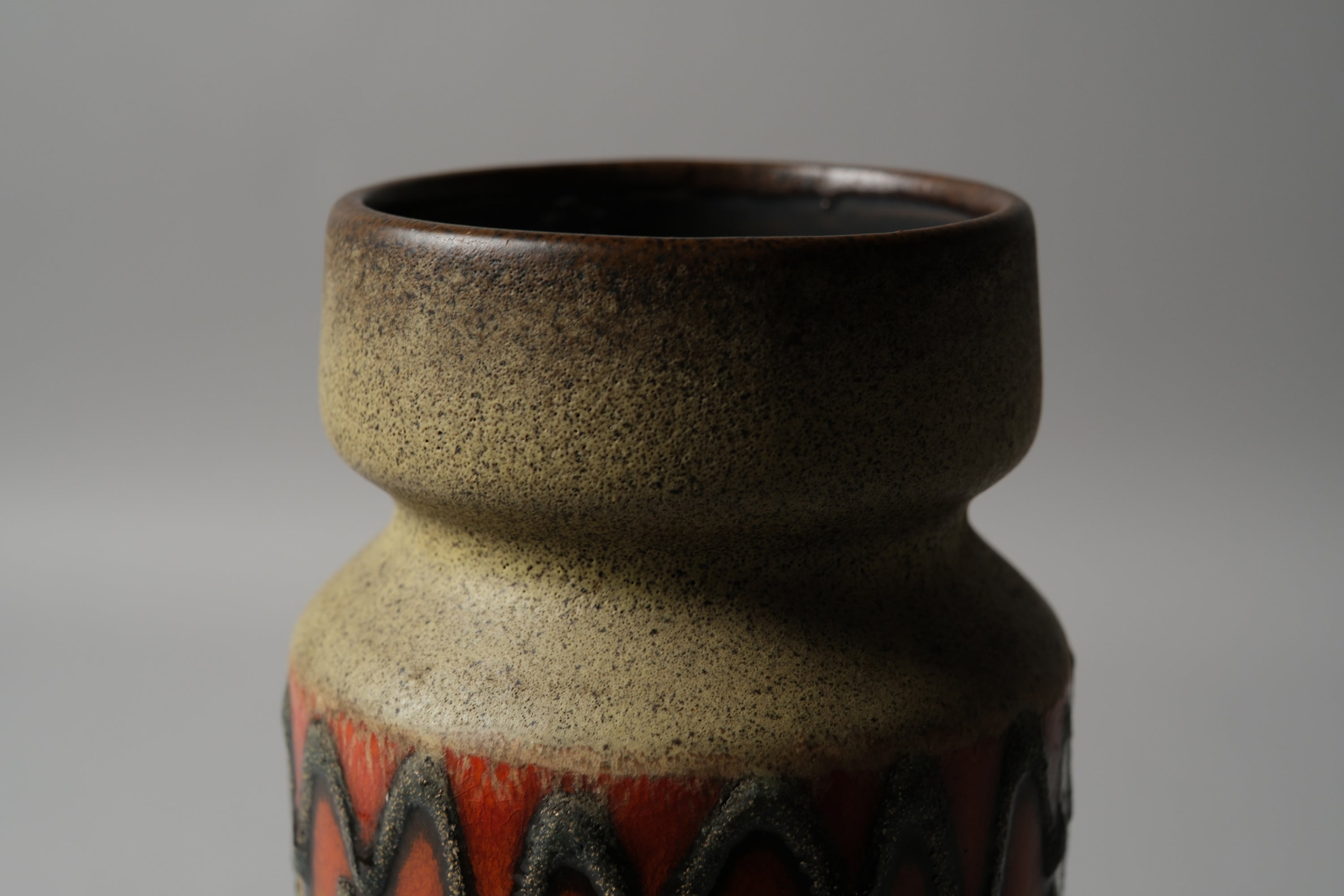 VEB Haldensleben fat lava vase, showing dark brown matte neck glaze transitioning to the relief decoration below, East Germany 1960s