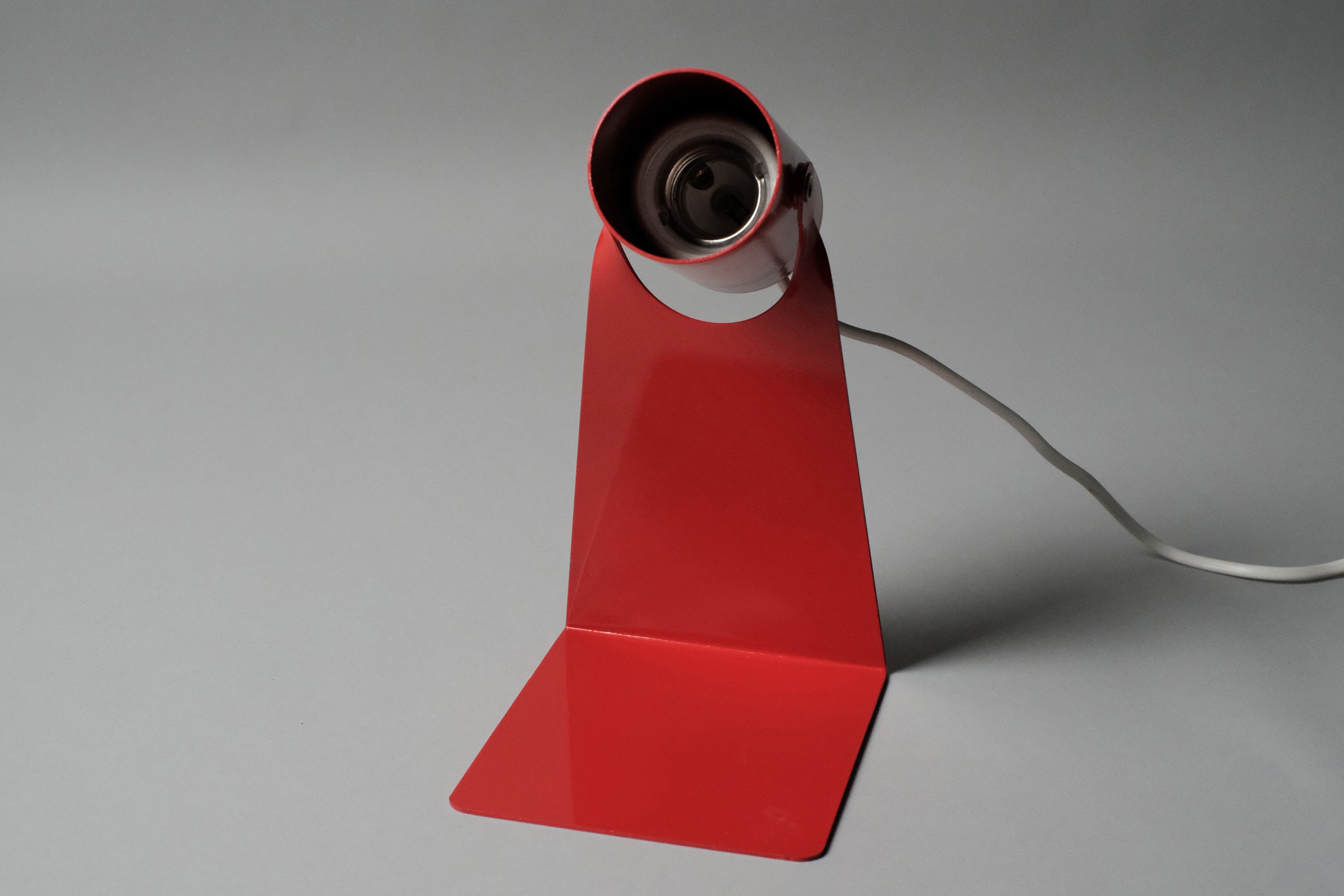 Front-facing view of the E27 ceramic socket on the vintage 1970s Gnosjo Konstsmide Swedish MCM red metal industrial desk lamp with the bulb removed.