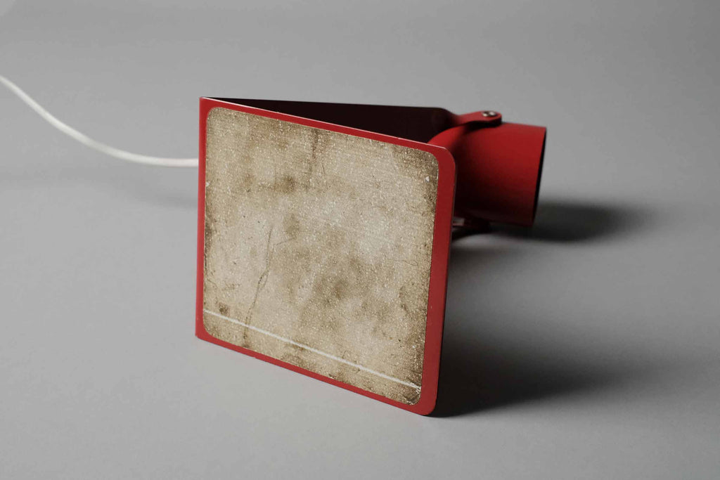 The underside of the vintage 1970s Gnosjo Konstsmide Swedish MCM red metal industrial desk lamp revealing the protective foam padded base.