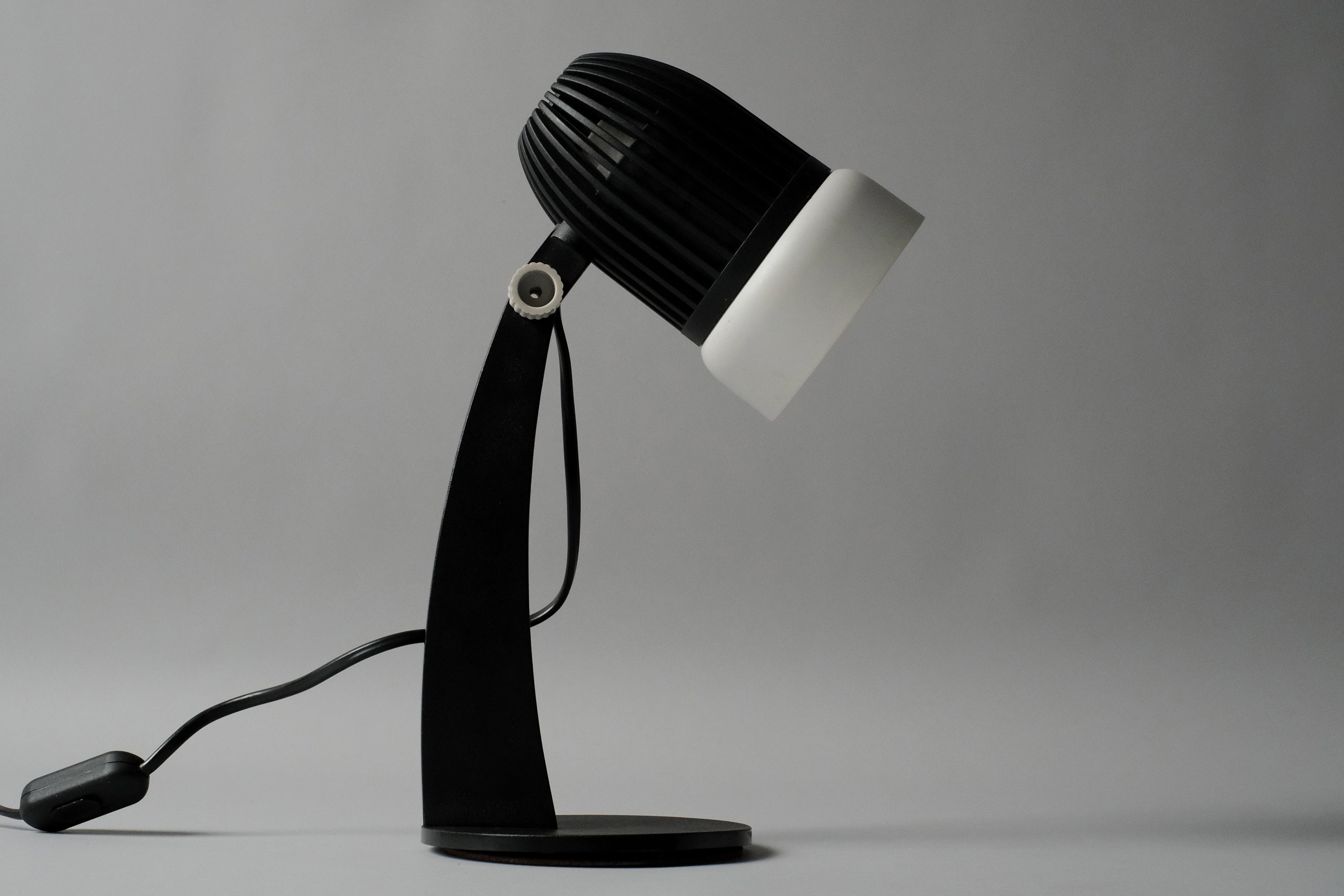 A side view of the vintage 1970s Aro Leuchte modernist adjustable desk lamp showing the sleek curved neck and balanced circular base.