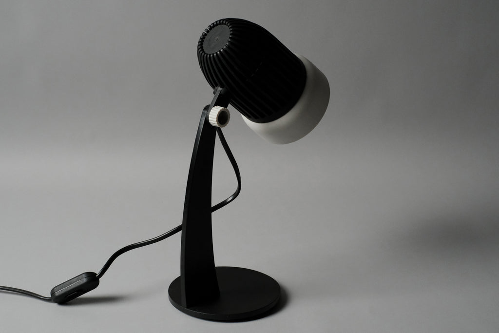 A rear perspective shot of the vintage 1970s Aro Leuchte modernist adjustable desk lamp highlighting the contrast between the matte black and white finishes.