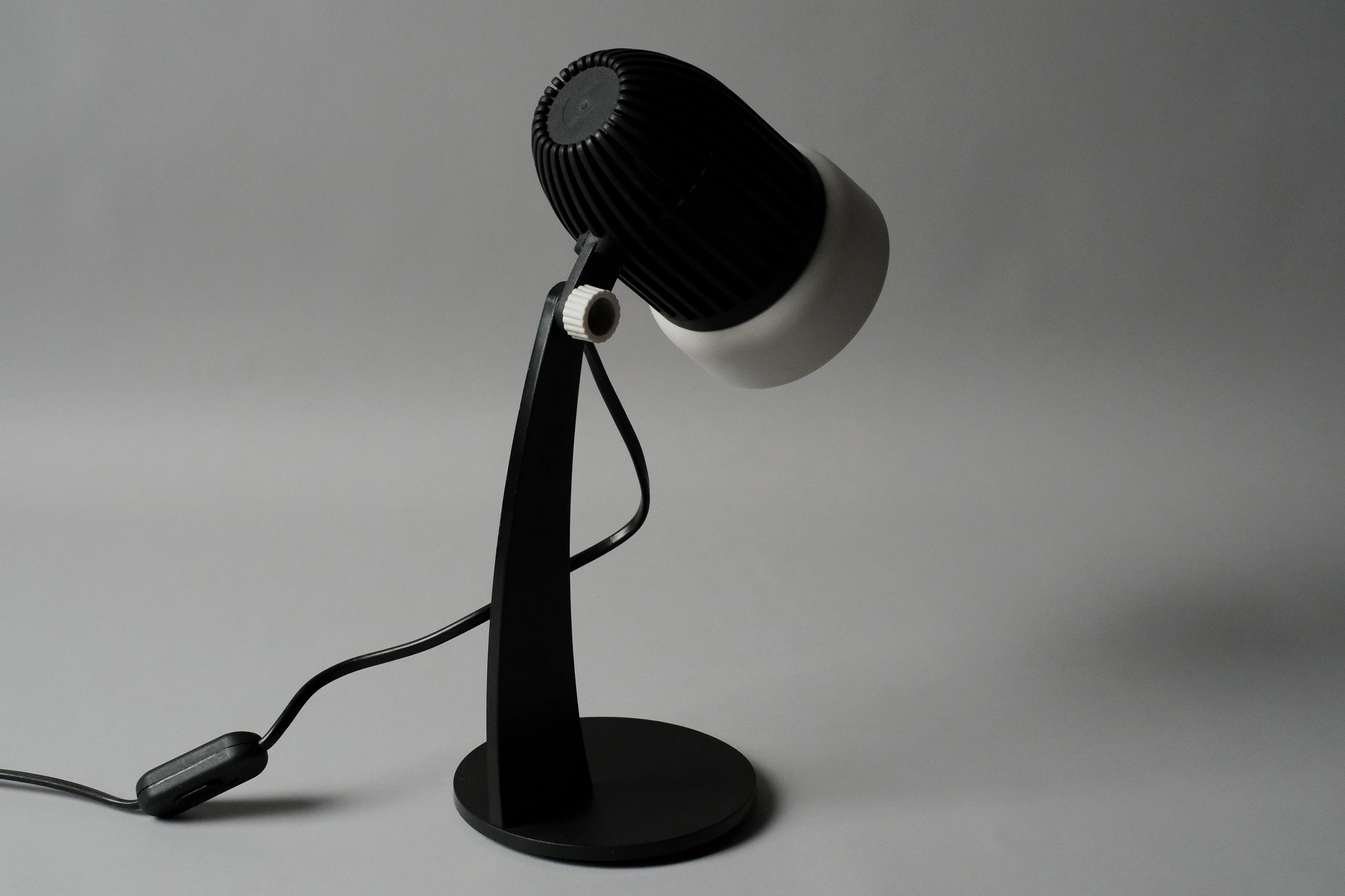 A rear perspective shot of the vintage 1970s Aro Leuchte modernist adjustable desk lamp highlighting the contrast between the matte black and white finishes.