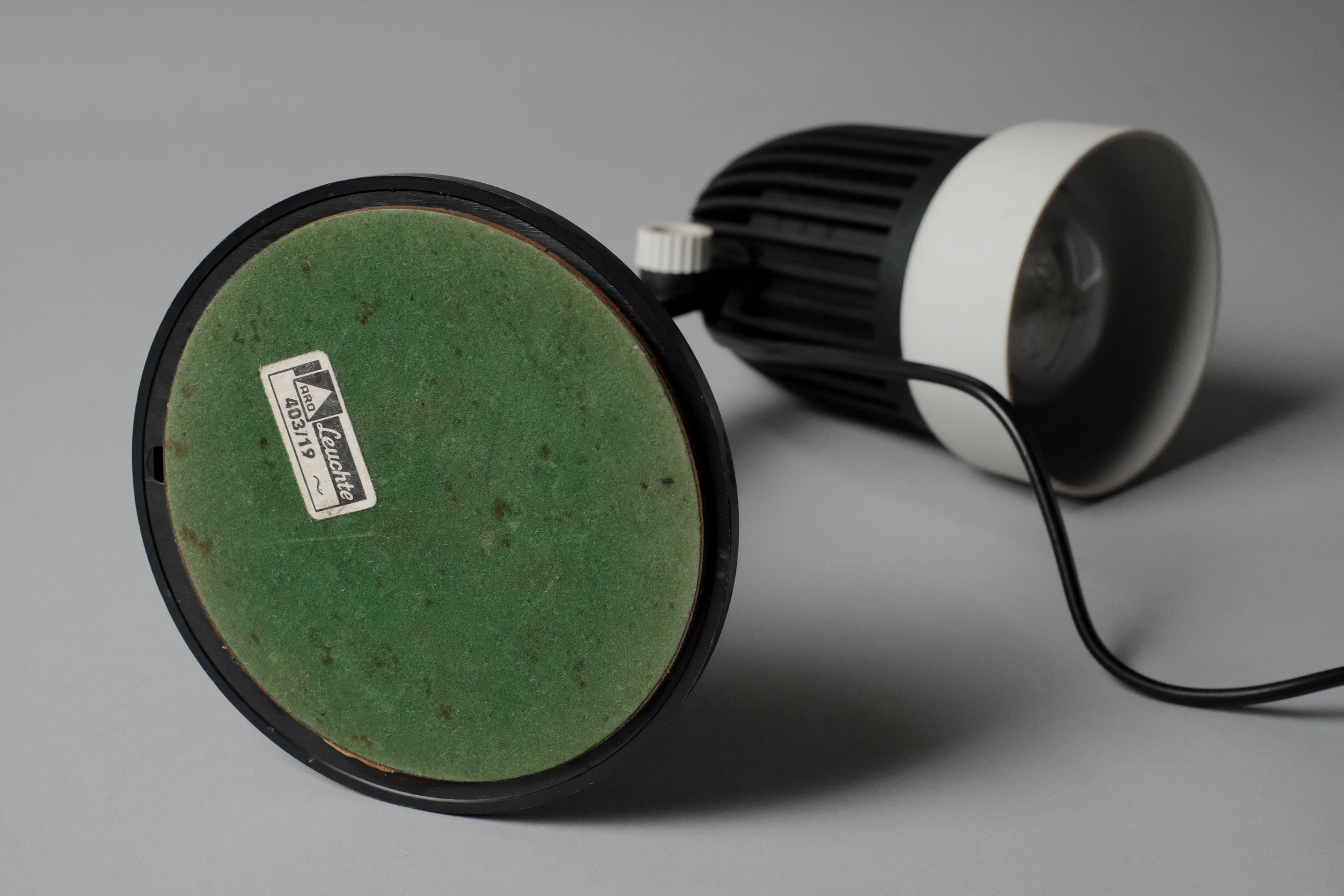 The underside of the vintage 1970s Aro Leuchte modernist adjustable desk lamp revealing the green felt protective padding and manufacturer's label.