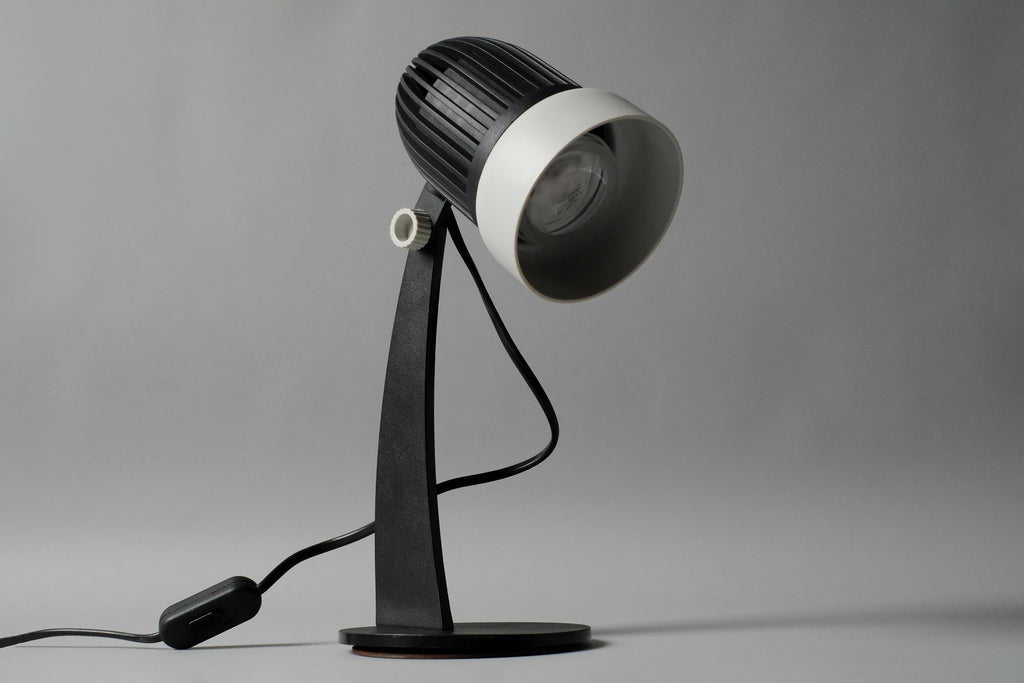 Primary studio profile of the vintage 1970s Aro Leuchte modernist adjustable desk lamp in black and white featuring a ribbed spherical head.