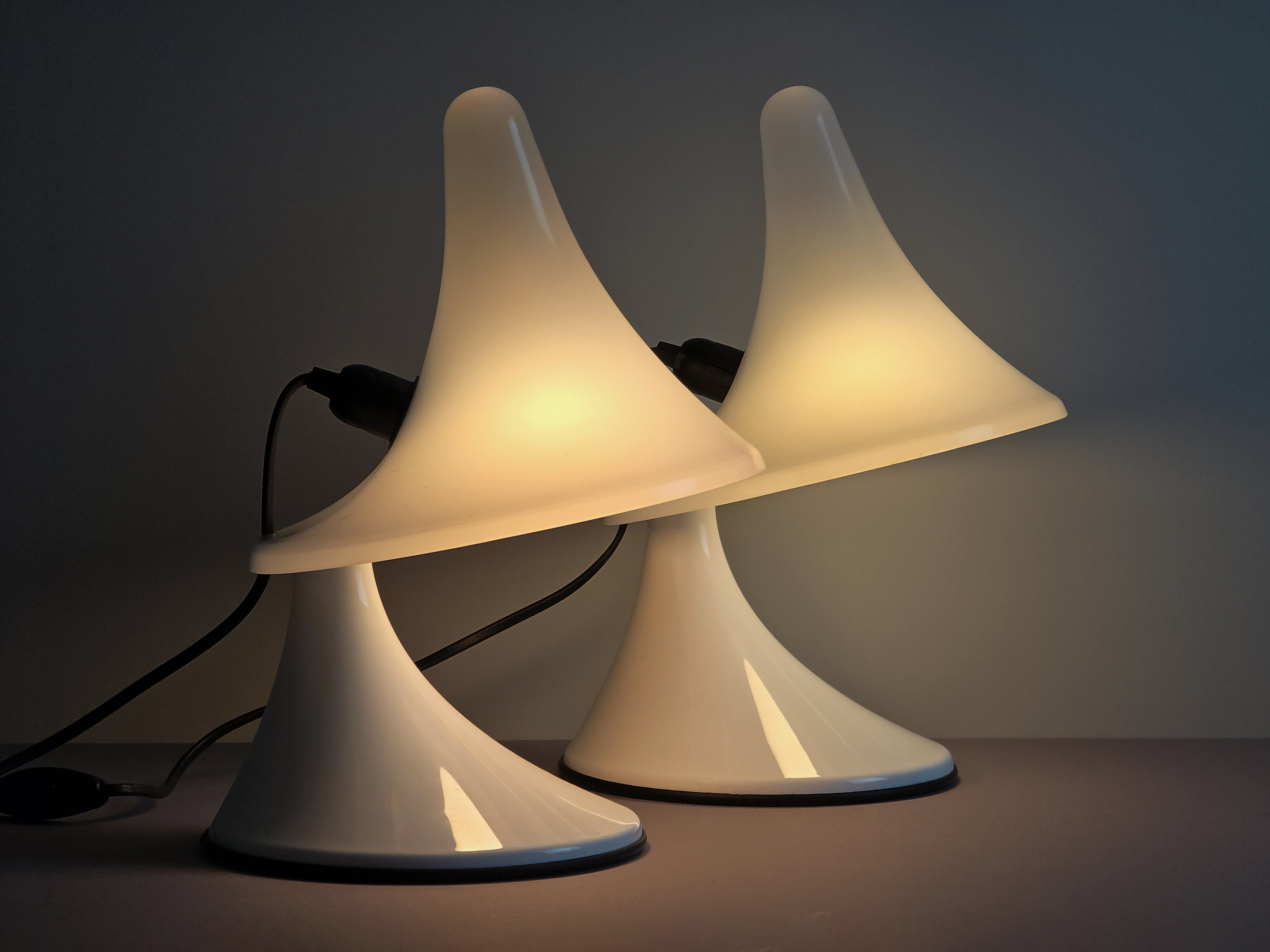 Side profile of the Karin-M Italian design lamps, highlighting the elegant organic curves of the Perspex body. The image shows a pair of the lamps, amber lit.