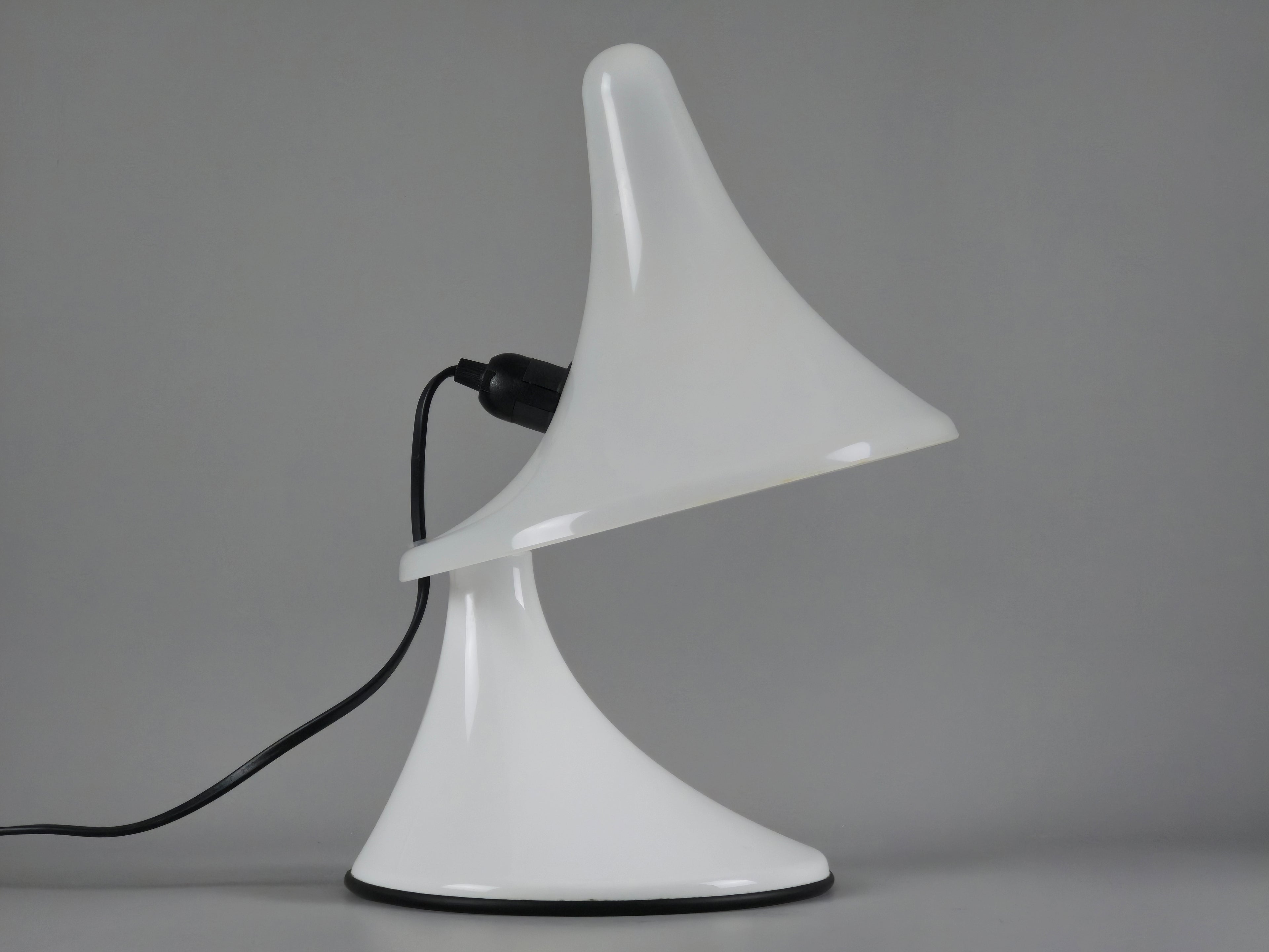 Low-angle shot of the white Art Plex lamp, emphasizing its sculptural Space Age silhouette against a grey background.