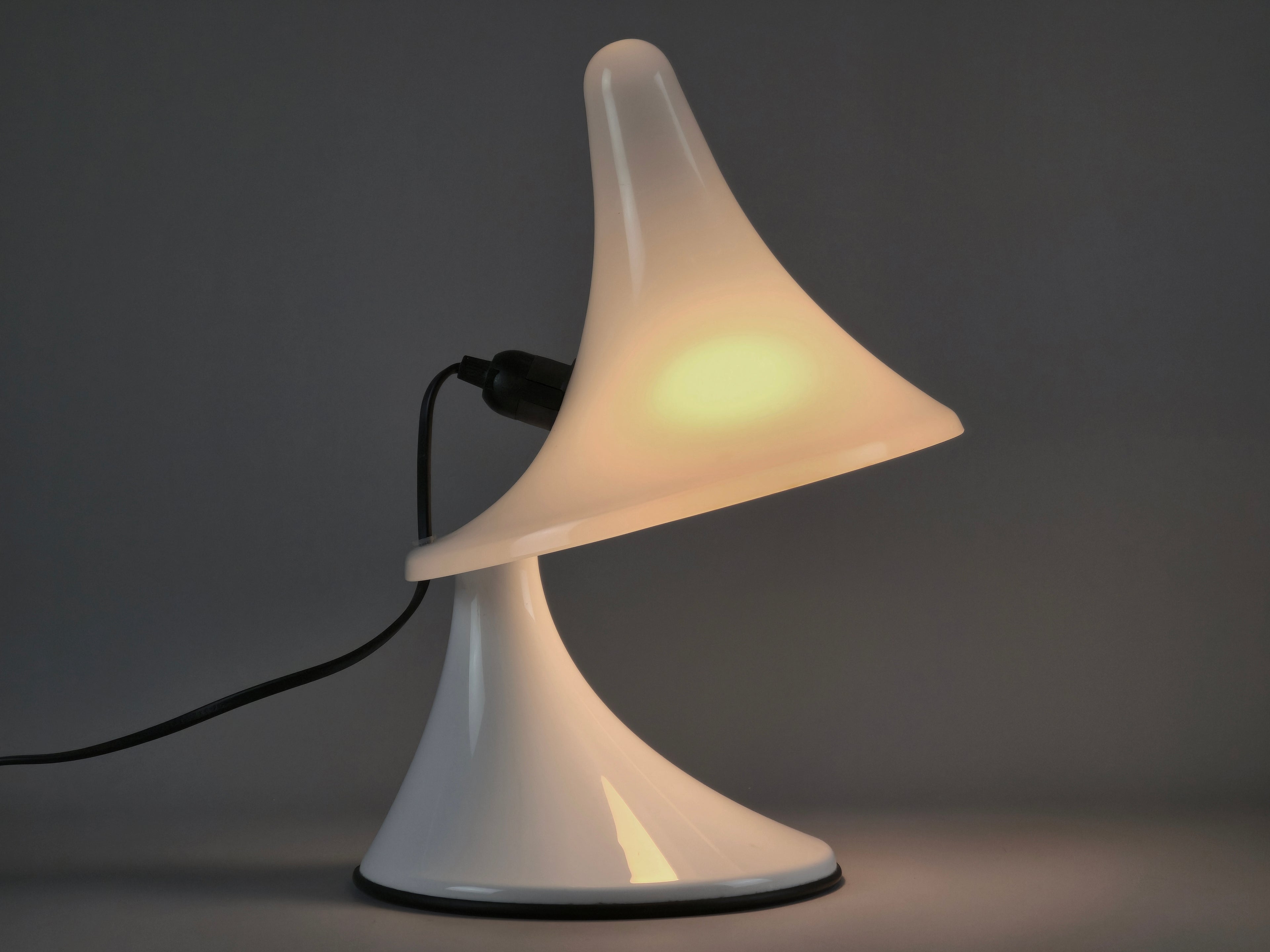 Vintage Art Plex Venezia Karin-M lamp illuminated, showing the soft glow through the white trumpet-shaped shade.