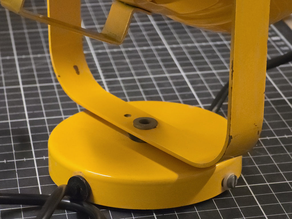 Macro close-up of the yellow metal base of a vintage wall lamp.
