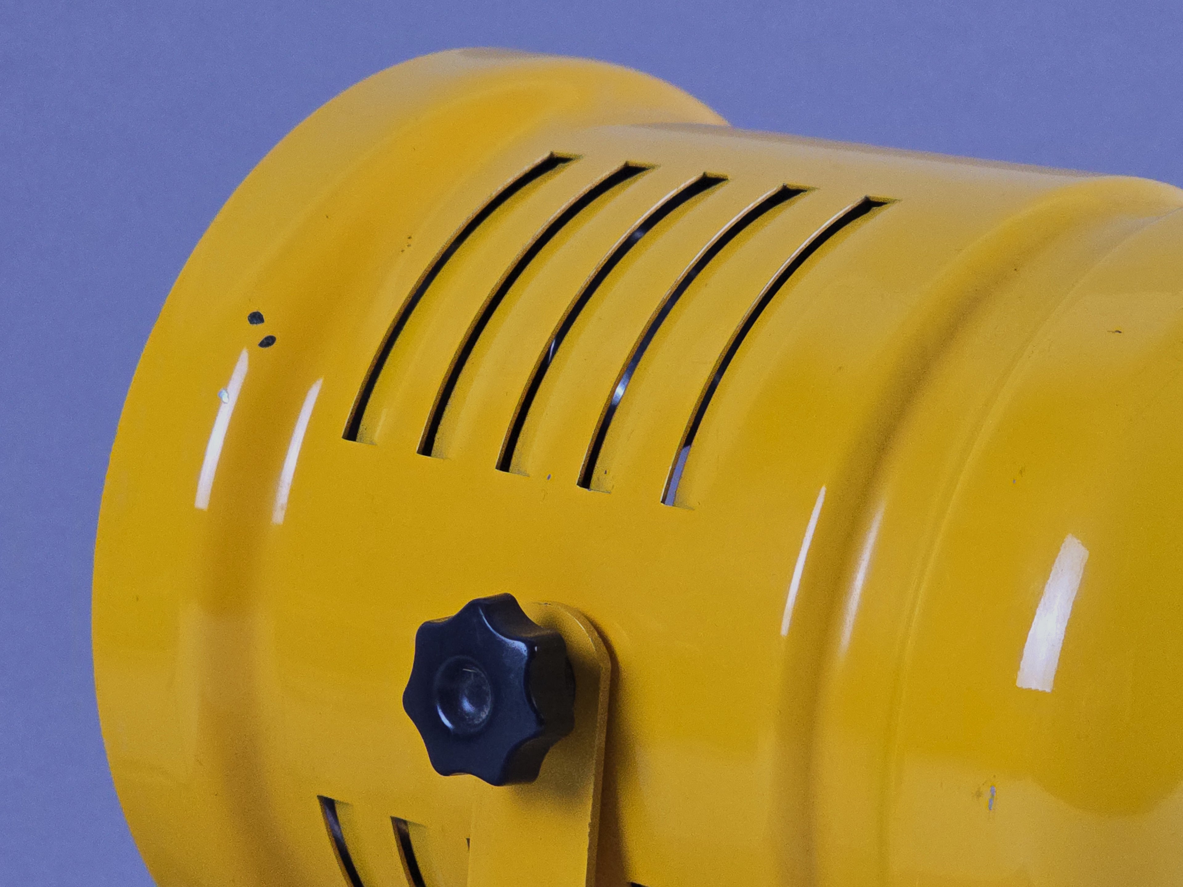 Macro close-up of yellow wall lamp showing the venting slots on the shade.