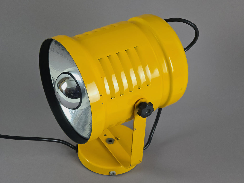 Top down angled view of yellow industrial wall light showing the vented slots, and silver light ring.