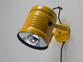 Vintage 1980s industrial wall lamp in yellow enameled metal with adjustable knobs, wall mounted on a neutral background with black cord.